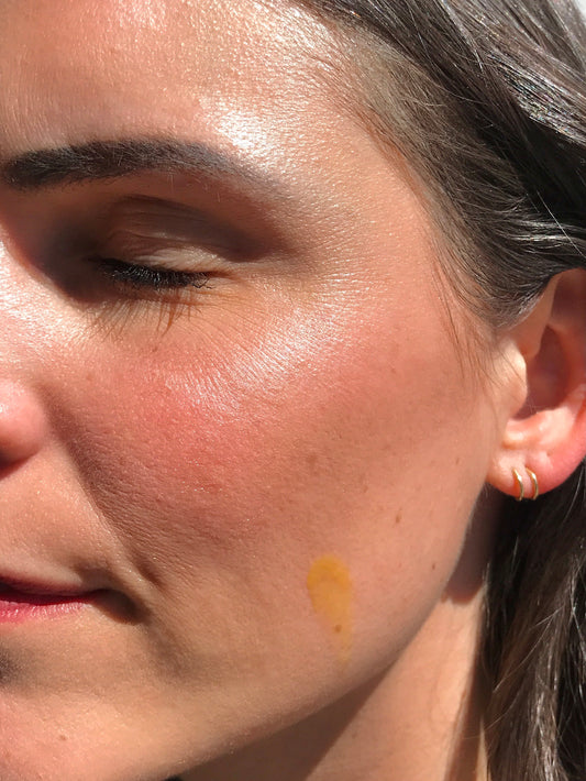 close-up of woman with hibiscus night renewal on her skin in sunlight