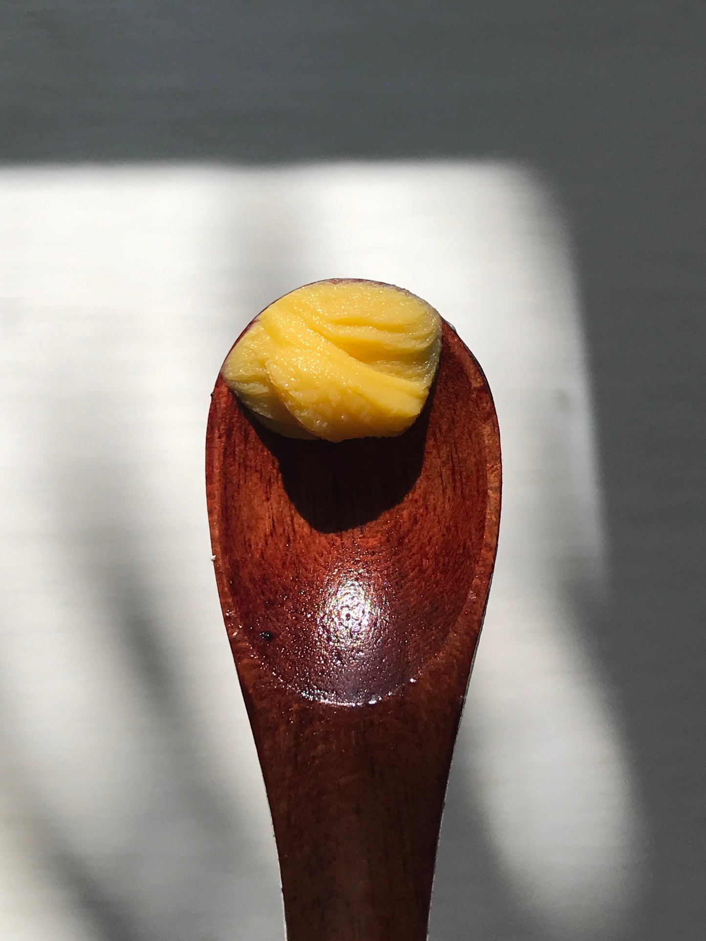 wooden spoon with scoop of hibiscus glow balm