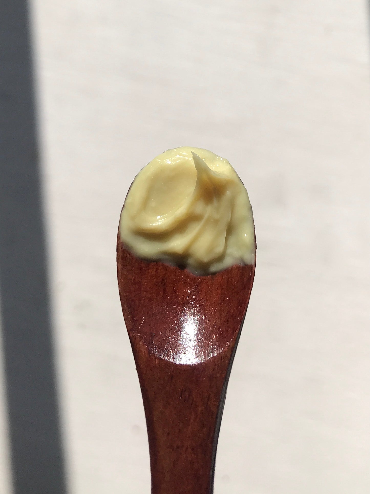 wooden spoon with banana barrier cream scoop on it