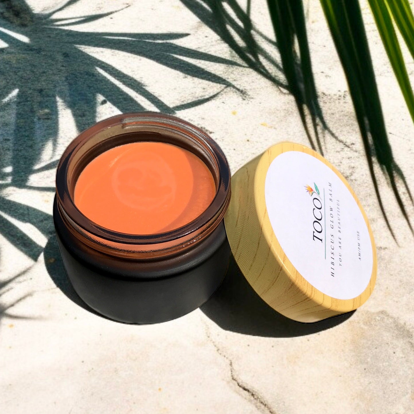 Hibiscus glow balm in a black jar with lid
