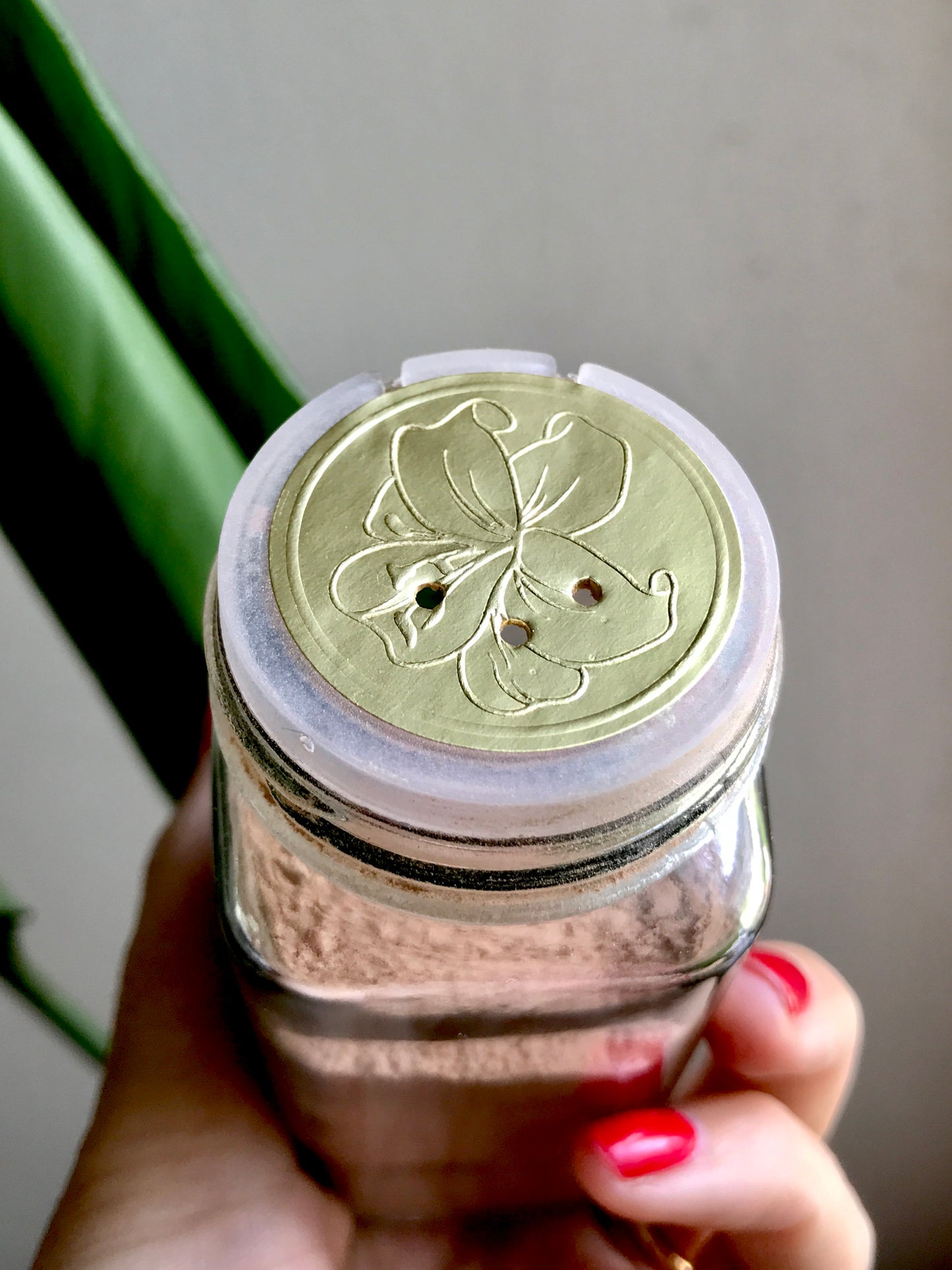 dry shampoo shaker jar with foil sticker with 3 holes in it