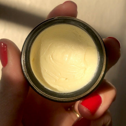 Hand holding container of Banana Eye Concentrate with a close-up view.