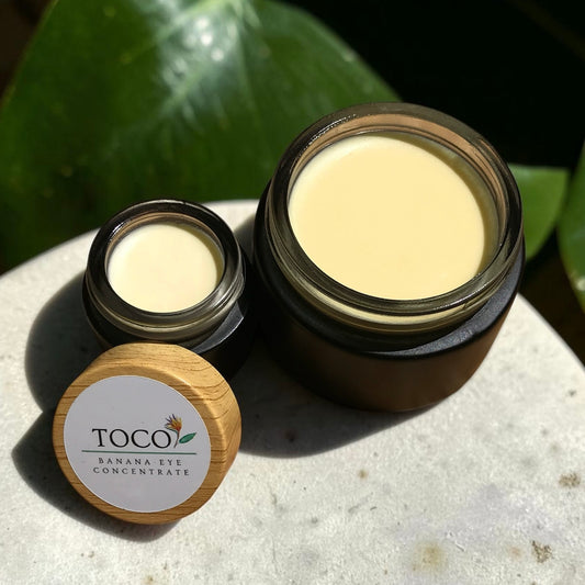 Banana Barrier Cream & Banana Eye Concentrate on stone with tropical leaf in background