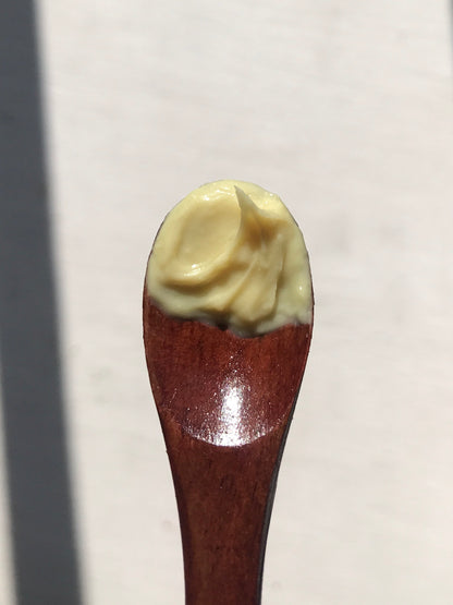 wooden spoon with banana barrier cream scoop on it