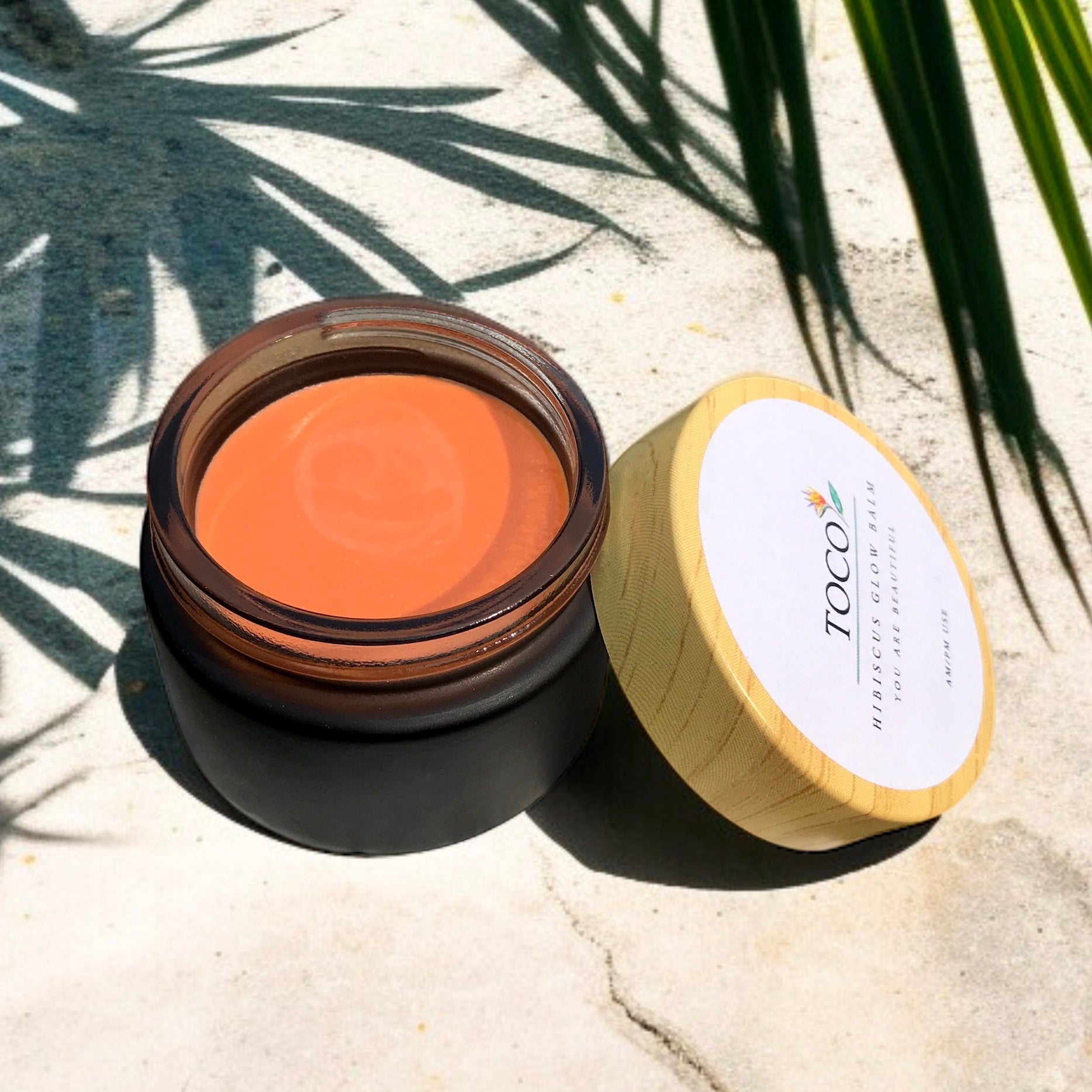 Hibiscus glow balm in a black jar with lid