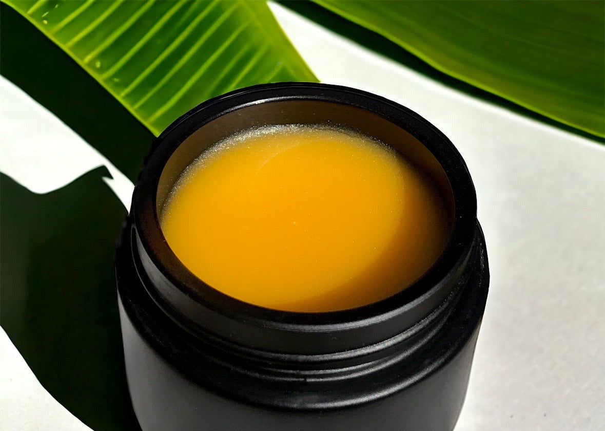 close-up of hibiscus glow balm in black glass jar