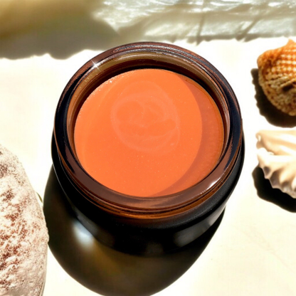 black jar of Hibiscus Glow Balm with seashells around it